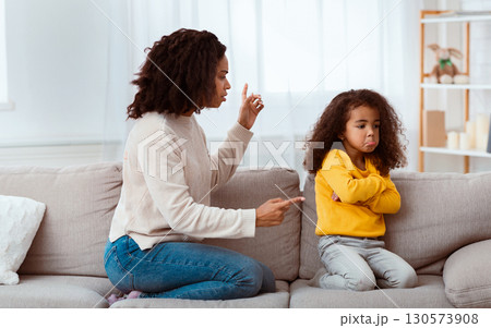 Angry Black Mother Scolding Kid Shouting At Sad Daughter Sitting On Sofa At Home. Family Quarrels And Problems Angry Black Mother Scolding Kid Shouting At Sad Daughter Sitting On Sofa At Home. Family Quarrels And Problems 130573908