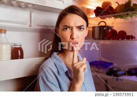 Don't bother me. Angry hungry woman opening fridge late, gesturing on camera 130573951