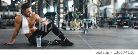 Online personal trainer on mobile phone. Muscular man using cellphone at gym, free space, web-banner Online personal trainer on mobile phone. Muscular man using cellphone at gym, free space, web-banner 130574116