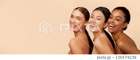 Three Diverse Ladies Models Smiling To Camera Posing Over Beige Background. Studio Shot Three Diverse Ladies Models Smiling To Camera Posing Over Beige Background. Studio Shot 130574236