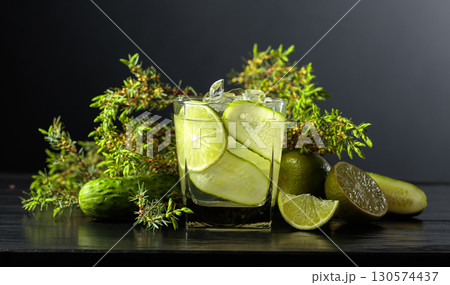 Cocktail Gin-tonic with ice, lime, cucumber, and juniper branches. 130574437