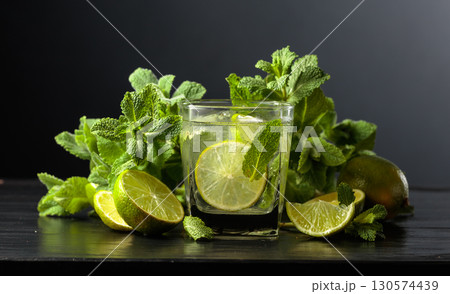 Mojito with ice, lime, and mint on a black background. 130574439