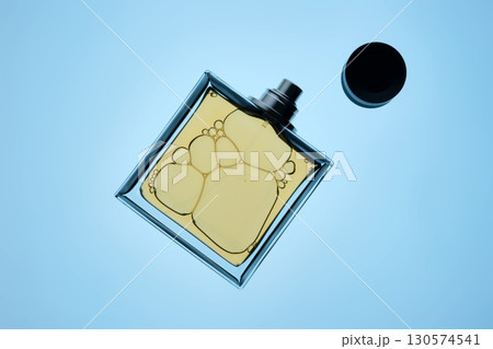 A bottle of perfume with a spray gun on a blue background with an illuminated texture. A bottle of perfume with a spray gun on a blue background with an illuminated texture. 130574541