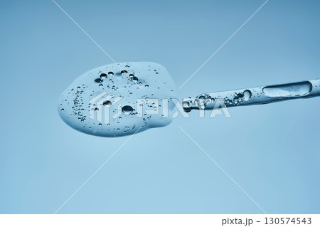 A pipette with hyaluronic serum on a blue background. 130574543