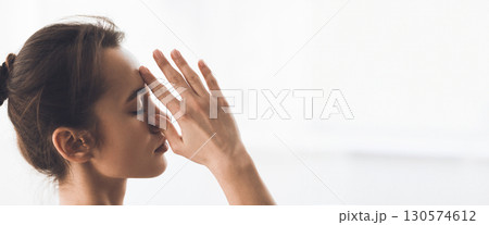 A woman performs a seated yoga twist in a well-lit studio, enjoying the calm and focus of her morning practice, copy space A woman performs a seated yoga twist in a well-lit studio, enjoying the calm and focus of her morning practice, copy space 130574612