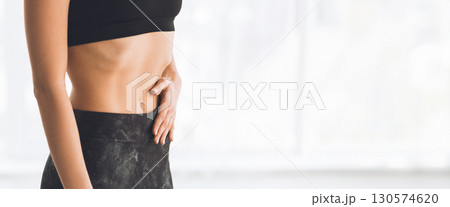 A young woman is performing a yoga pose with hands in prayer position, illuminated by gentle morning light, cropped, copy space A young woman is performing a yoga pose with hands in prayer position, illuminated by gentle morning light, cropped, copy space 130574620