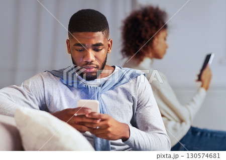 Indifference in relationships. Black couple using cellphones and ignoring one another 130574681