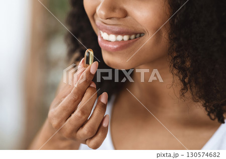 Beauty Supplement. Closeup Of Smiling Black Woman Taking Vitamin Pill Capsule, Having Diet Nutrition, Cropped Image Beauty Supplement. Closeup Of Smiling Black Woman Taking Vitamin Pill Capsule, Having Diet Nutrition, Cropped Image 130574682