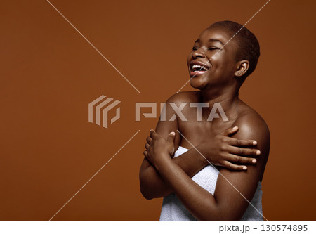 Chherful Beautiful Black Lady Standing With Folded Arms Wrapped In Towel After Bath, Cute African American Female With Short Hair Enjoying Her Natural Beauty, Posing Over Brown Background, Copy Space 130574895