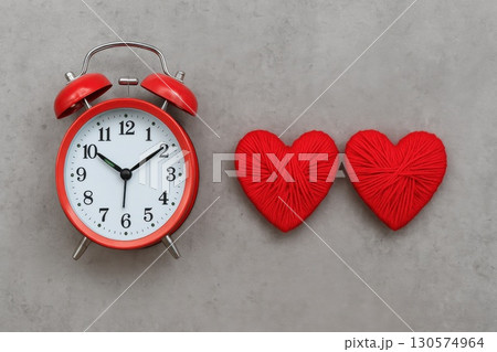 Romantic Time Symbolism Red Vintage Alarm Clock with Heart-Shaped Yarn Minimalist Concrete Setting Love and Punctuality 130574964