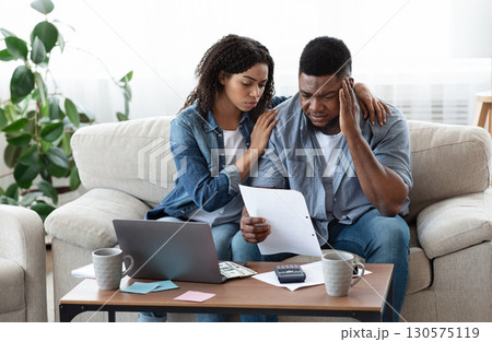 Family Financial Crisis Concept. Depressed Black Couple Looking At Invoice, Not Able To Pay Huge Bills, Suffering From Coronacrisis At Home 130575119