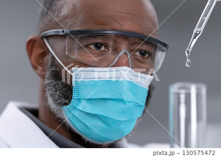 Scientist conducts experiment in laboratory with pipette and test tube during research process 130575472