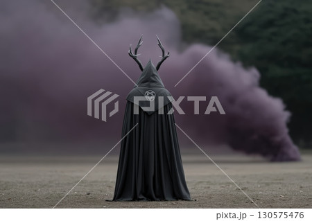 Mysterious figure in black cloak with antlers amidst purple smoke in a wooded area 130575476