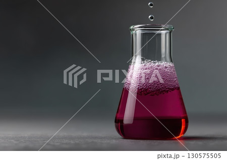 Colorful liquid bubbling in a glass flask during a chemistry experiment in a lab 130575505