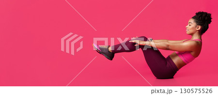 Young sporty afro woman practicing over red background doing crisscross exercise, bicycle crunches pose sitting on floor, copy space Young sporty afro woman practicing over red background doing crisscross exercise, bicycle crunches pose sitting on floor, copy space 130575526