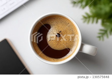 Coffee cup with smiley face foam art in a cozy workspace at morning 130575648