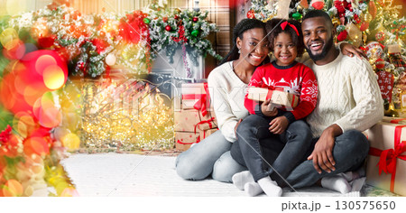 Christmas family portrait. Happy african american father, mother and daughter posing near Xmas tree in decorated living room Christmas family portrait. Happy african american father, mother and daughter posing near Xmas tree in decorated living room 130575650