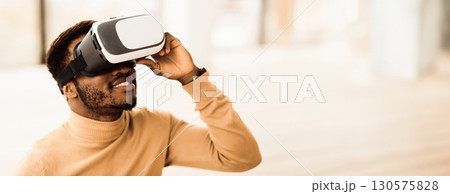 VR Technology. Black man wearing virtual reality glasses experiencing innovative technology, copy space VR Technology. Black man wearing virtual reality glasses experiencing innovative technology, copy space 130575828