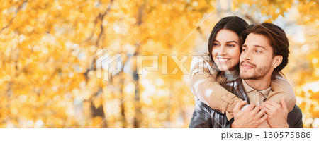 Woman in love hugging her handsome man from behind, one day at autumn forest, panorama with copy space Woman in love hugging her handsome man from behind, one day at autumn forest, panorama with copy space 130575886