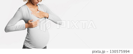 Afro pregnant woman suffering from breast pain, touching chest over white studio background, crop Afro pregnant woman suffering from breast pain, touching chest over white studio background, crop 130575994