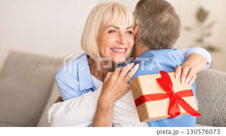 Happy wife hugging husband for the present, being grateful for birthday gift 130576073