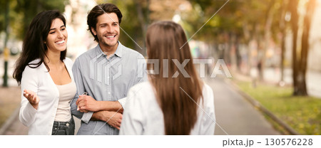 Married Couple Meeting Single Female Friend Walking Outdoor In Park. Friendship With Ex-Boyfriend Concept. Selective Focus Married Couple Meeting Single Female Friend Walking Outdoor In Park. Friendship With Ex-Boyfriend Concept. Selective Focus 130576228