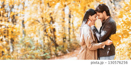 Romantic couple hugging and talking about love, dating in autumn park, copy space 130576256