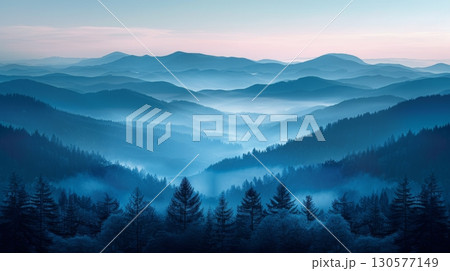 A mountain range covered in fog creating a mystical and obscured view of the peaks and valleys. 130577149