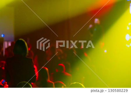 Colorful illuminated concert venue with crowd and stage lighting effects Colorful illuminated concert venue with crowd and stage lighting effects 130580229