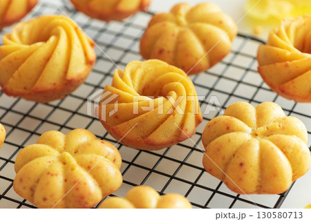 Autumn-Themed Mini pumpkin Cakes with Seasonal Decorations on White Background 130580713