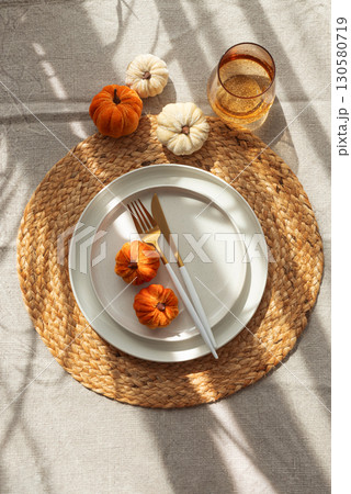 Autumn Table Setting with Decorative Pumpkins and Seasonal Leaves 130580719