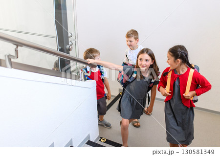 Children with backpacks climbing stairs at school. Children with backpacks climbing stairs at school. 130581349