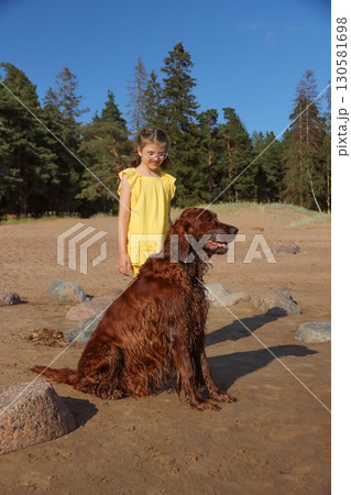 Portrait of little girl in yellow dress with Irish Setter on beach on sunny day Portrait of little girl in yellow dress with Irish Setter on beach on sunny day 130581698