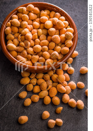 Peanuts in a crispy crust in bowl on black table. Peanuts in a crispy crust in bowl on black table. 130581822