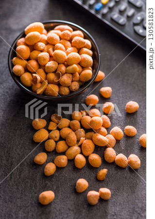 Peanuts in a crispy crust in bowl on black table. Peanuts in a crispy crust in bowl on black table. 130581823