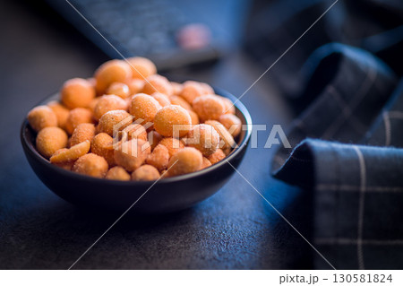 Peanuts in a crispy crust in bowl on black table. 130581824