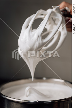 Whipped marshmallow cream pulled from mixer, close-up of airy texture and sweet dessert base 130582044