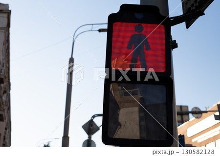 Red pedestrian traffic light shows dont walk signal, part of modern digital system ensuring safety for pedestrians in urban areas. Everyday life in contemporary cities 130582128