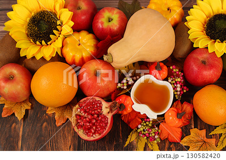 Thanksgiving banner, autumn background with apples, pomegranates, pumpkins, honey, grapes, flowers under sunflowers and leaves on wooden table, harvest concept, healthy natural food advertising Thanksgiving banner, autumn background with apples, pomegranates, pumpkins, honey, grapes, flowers under sunflowers and leaves on wooden table, harvest concept, healthy natural food advertising 130582420