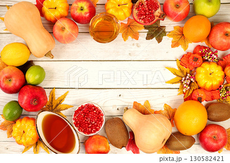 Thanksgiving banner, autumn background with wreath of maple leaves, red rowan, pumpkin, pomegranate and apples on old wooden table, creative design template with space for text on screen Thanksgiving banner, autumn background with wreath of maple leaves, red rowan, pumpkin, pomegranate and apples on old wooden table, creative design template with space for text on screen 130582421