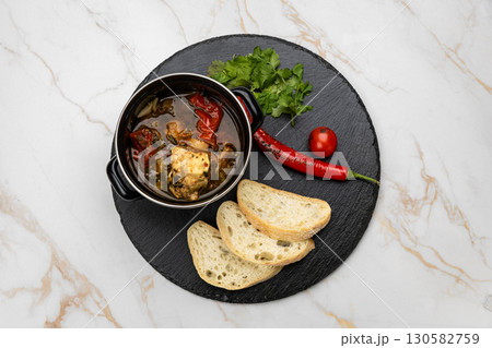 Traditional Georgian khashlama stew with beef, vegetables, herbs and bread on slate plate Traditional Georgian khashlama stew with beef, vegetables, herbs and bread on slate plate 130582759