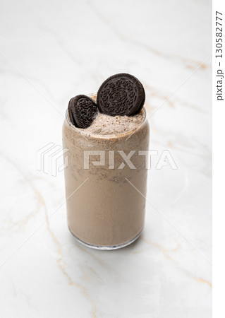 Creamy Oreo milkshake in a glass, topped with cookies on marble background 130582777