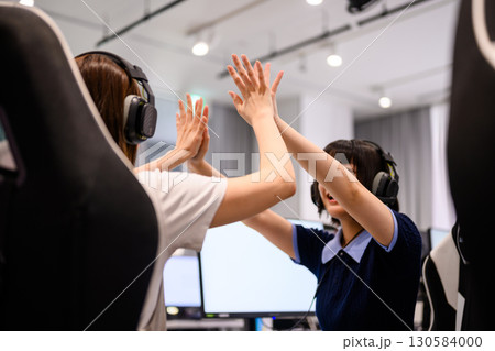 　ハイタッチで喜び合う女子学生たち 130584000