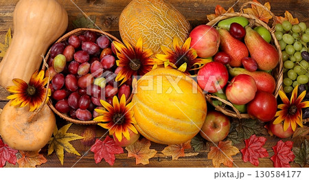 Happy Thanksgiving concept, fall background with seasonal fall berries, pumpkins, melons, apples, grapes and flowers on wooden background, harvesting in the village, top view 130584177