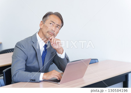 パソコンを見て考えるシニアビジネスマン パソコンを見て考えるシニアビジネスマン 130584196