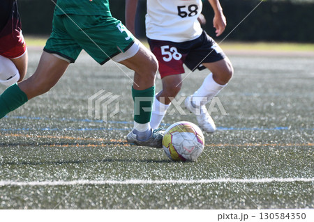 ドリブルするサッカー選手 130584350