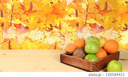 Apples and fruits in a box on a rustic table against a background of autumn leaves. Harvesting in the village, ecological food. Weight loss and diet concept, healthy eating, Apples and fruits in a box on a rustic table against a background of autumn leaves. Harvesting in the village, ecological food. Weight loss and diet concept, healthy eating, 130584421