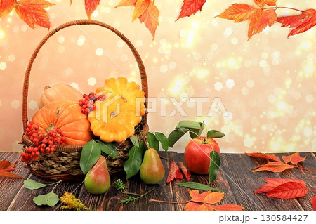 Basket with pumpkins, squash and apples on a wooden table.Autumn abstract composition with maple leaves on blurred bokeh background, thanksgiving day concept, banner or splash screen 130584427