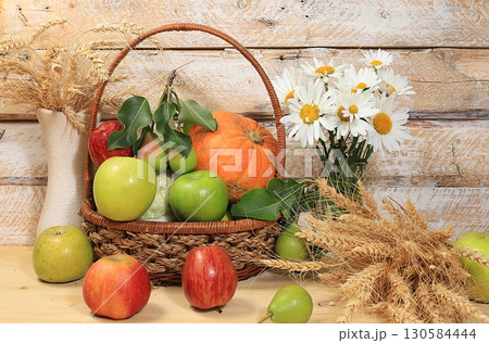 Autumn background with seasonal berries, melons, pears, cucumbers, wheat, apples and flowers on a wooden background. Happy Thanksgiving concept, copy space, healthy and natural food, selective focus. 130584444