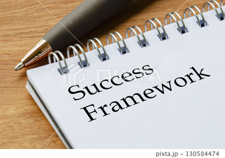 Close up notepad featuring Success Framework text on white lined pages in focus. Close up notepad featuring Success Framework text on white lined pages in focus. 130584474
